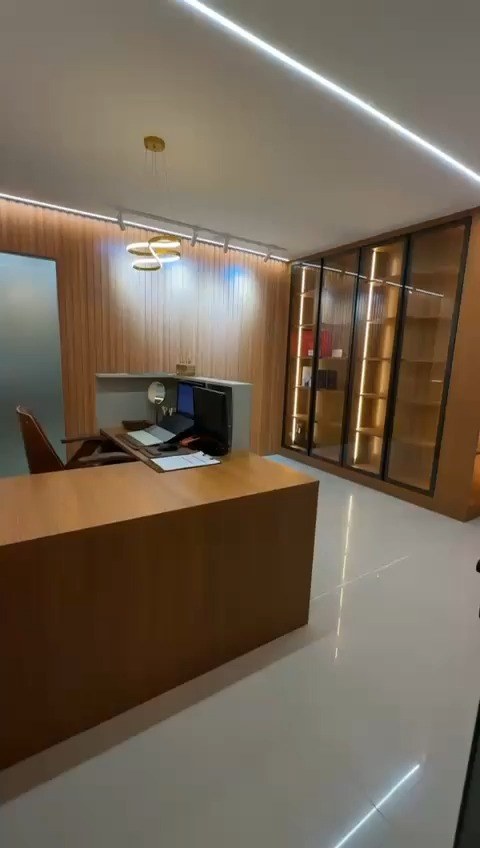 Consultório com mesa de atendimento e armário iluminado