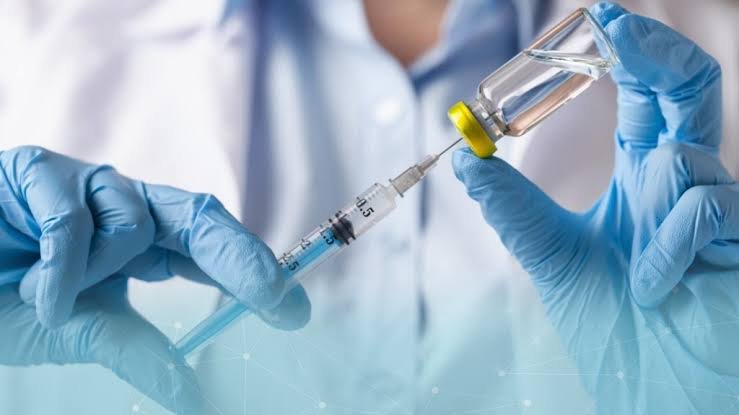 Profissional de luvas preparando uma seringa para protocolo regenerativo